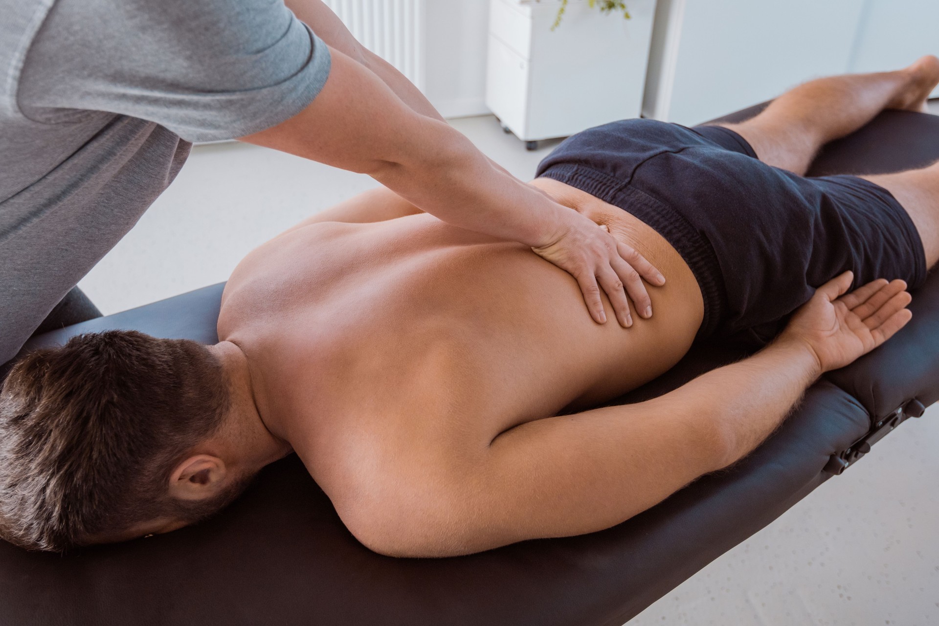 Physiotherapist massaging the back of the man